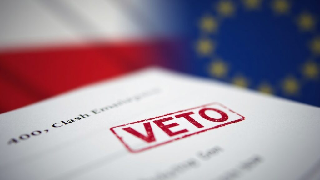 Center-focused veto document stamped VETO, with blurred Poland flag behind and an EU flag beside.