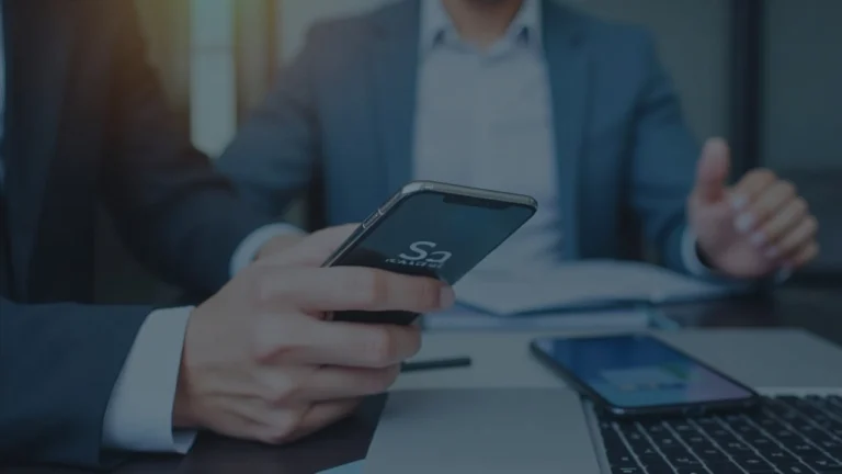 Newsroom scene with a smartphone showing the SoFi app and the XRP logo, signaling broad XRP access.